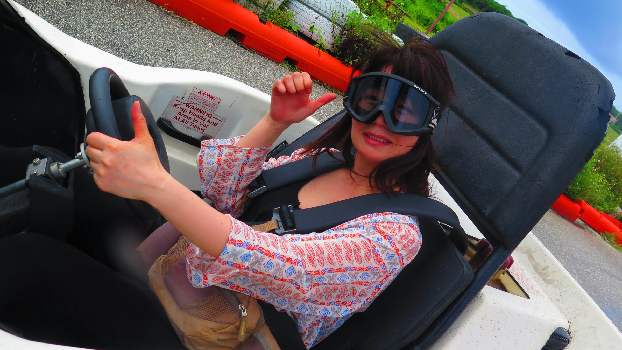 A woman giving the thumbs up while driving her go-kart