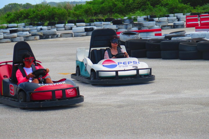 Two people driving their go-karts