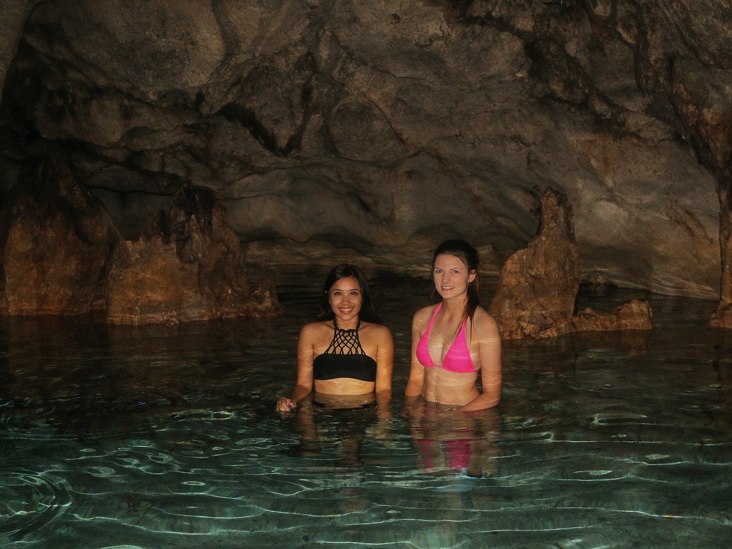 Two woman enjoying a swim in a cave