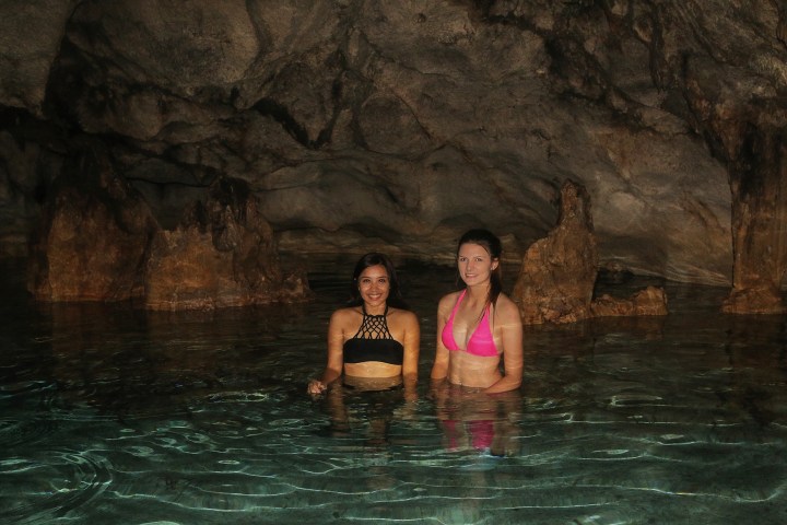 Two woman enjoying a swim in a cave