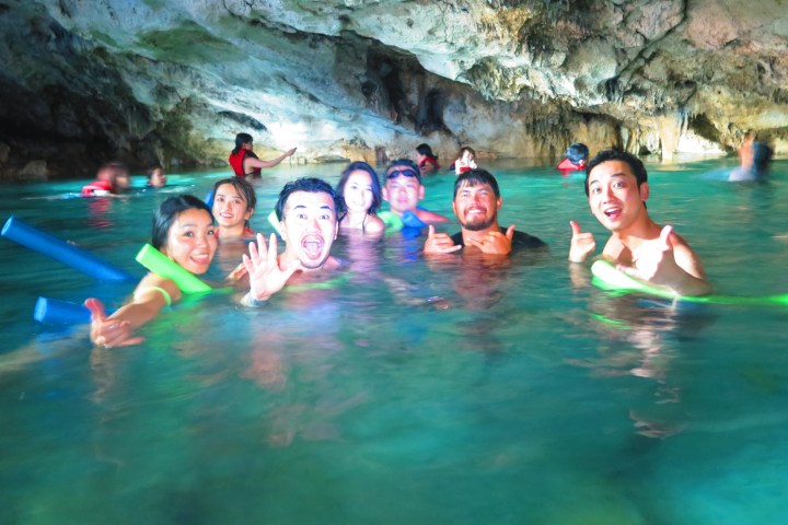 Group of people enjoying water in a cave.