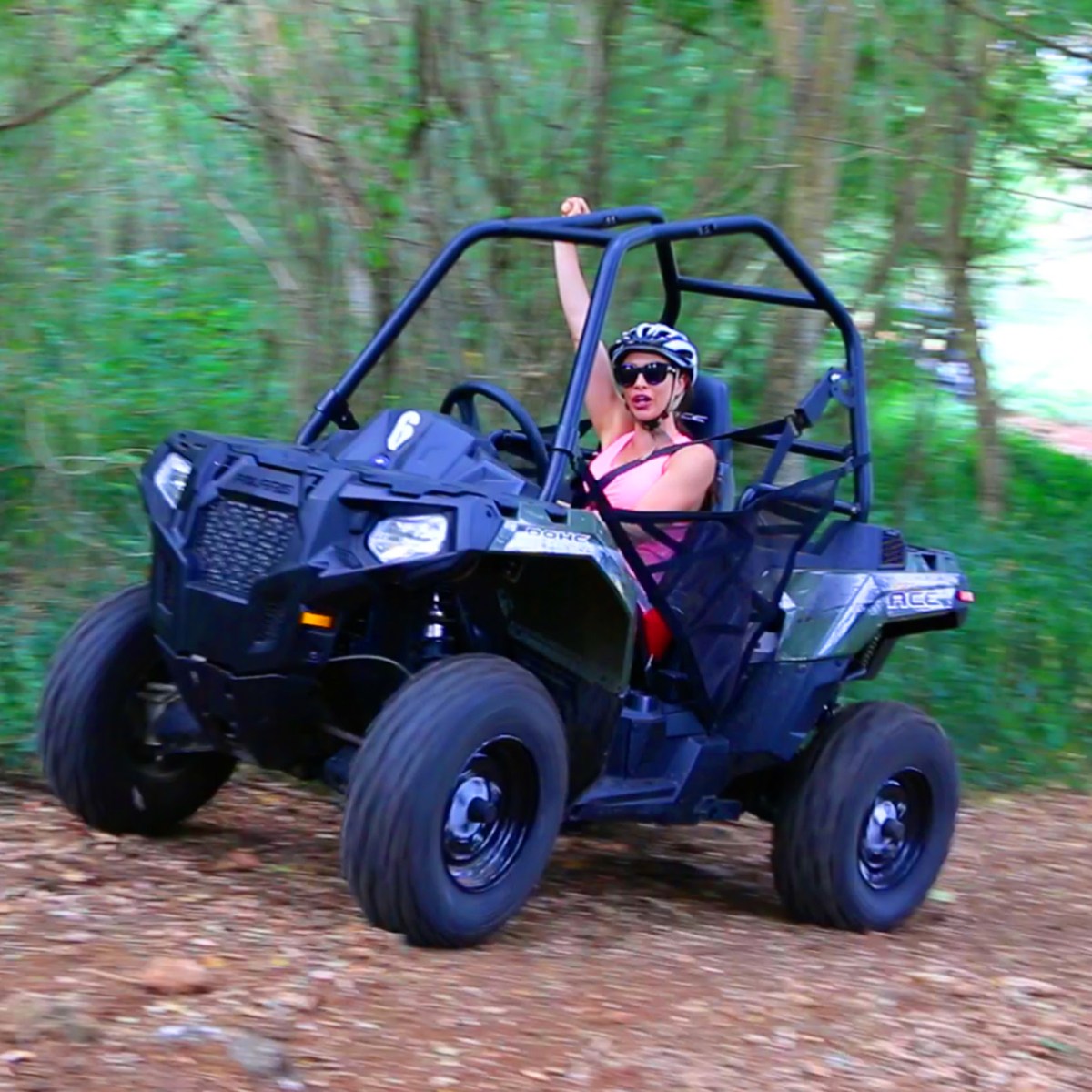 A woman pumping her fist as she drives her solo buggy