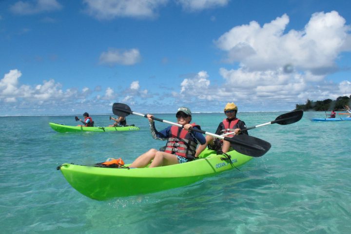 a group of people riding on the back of a boat in the water