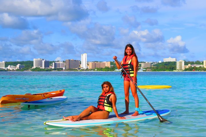 a young girl riding a wave on a surfboard in the water