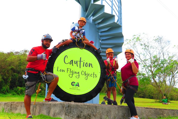 a group of people that are standing in the grass holding a kite